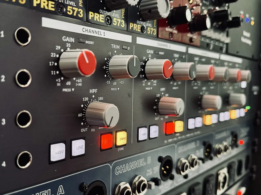 Grande console de mixage professionnelle avec faders et boutons.